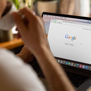 Onderneemster met een kop koffie zoekt op Google op haar laptop